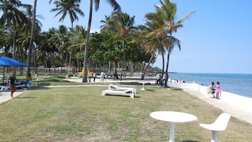 Aan het strand, wit zand, parasols, strandlakens