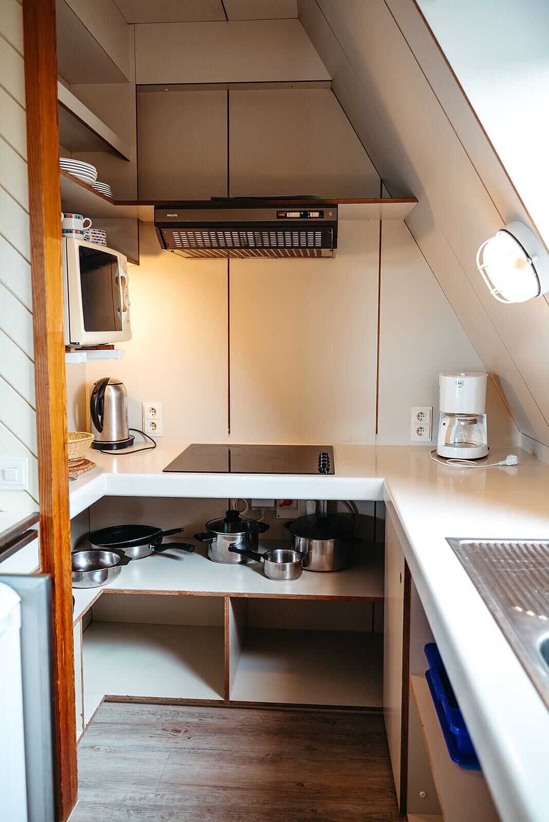A compact kitchen with a microwave, coffee maker, and gas stove.