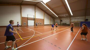 An indoor sports court with multiple players engaged in a game.
