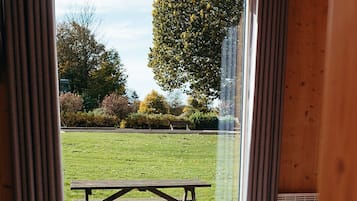 Habitación con vistas a un espacio verde y una mesa de picnic al aire libre.