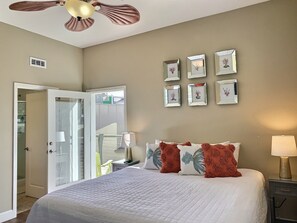 A bedroom with a bed, a ceiling fan, a door leading to a balcony, and framed pictures on the wall. - Fresh look at Shore Pleasure a family fav, steps from beach and downtown (Avila Beach)