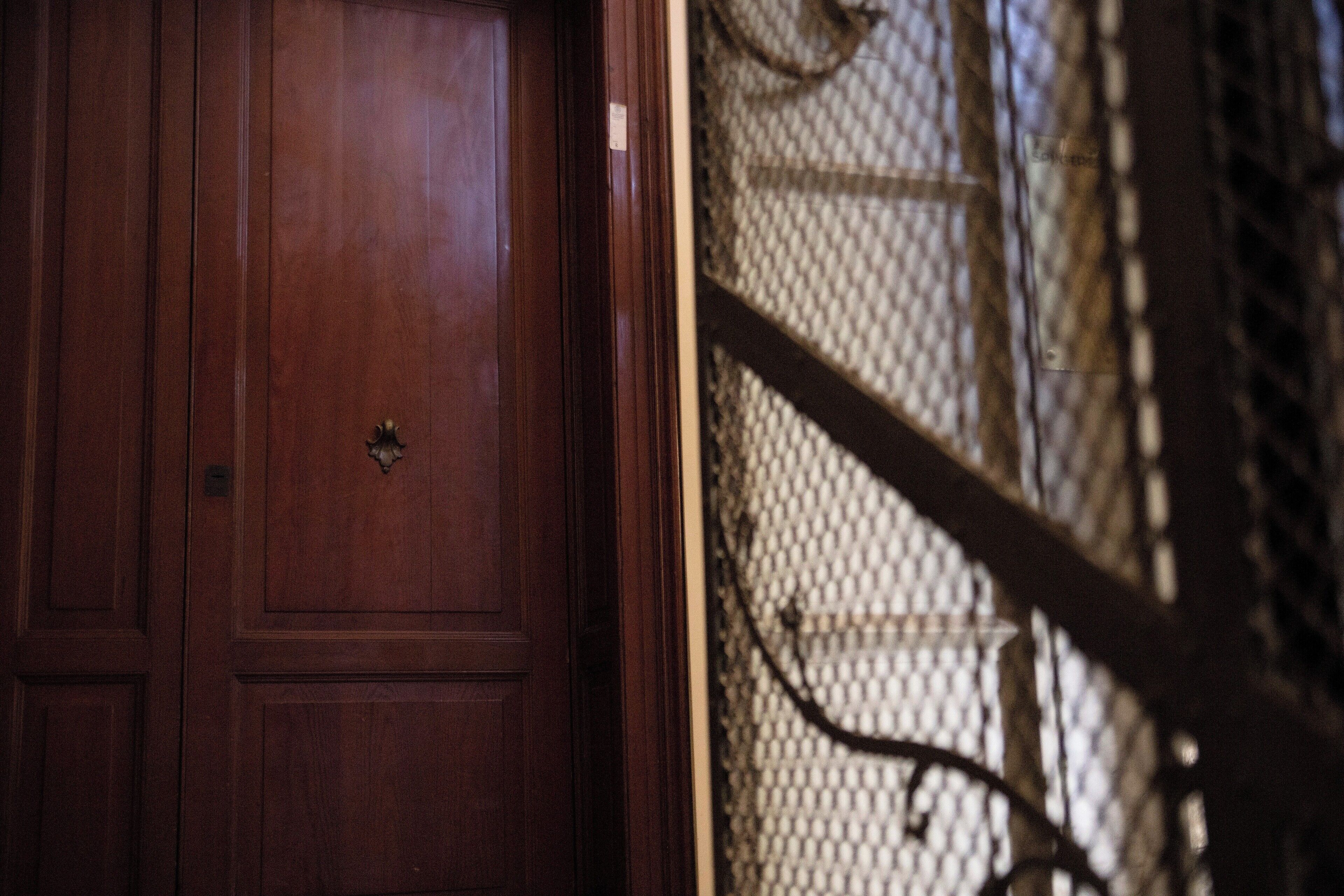 A wooden door with a brass handle and a metal lock.