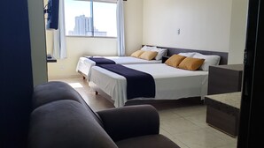 Ein Hotelzimmer mit zwei Betten, einem Sofa und einem kleinen Tisch.