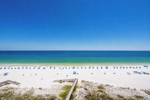 A beach with white sand, clear blue water, and a wooden boardwalk leading to the shore. - **WEEKLY SPECIALS!** Phoenix I - 11th Floor - 2 Bedroom (Orange Beach)