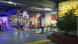 A restaurant with outdoor seating, a horse statue, and a sign for Cool Martin Resort. - Cool Martin Resort Hotel (Bacoor City)