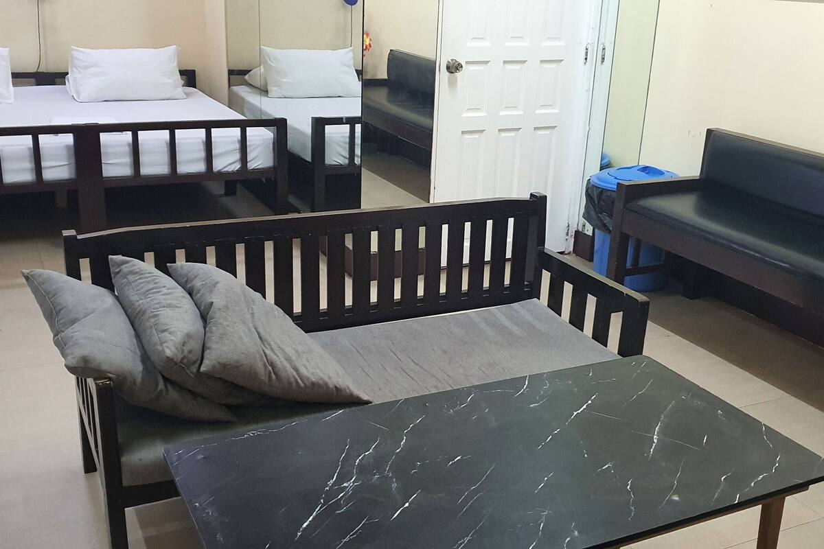 Una habitación con cama, sofá, mesa y banco.