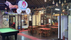 A billiards table, wooden tables, and a horse sculpture in a restaurant. - Cool Martin Resort Hotel (Bacoor City)