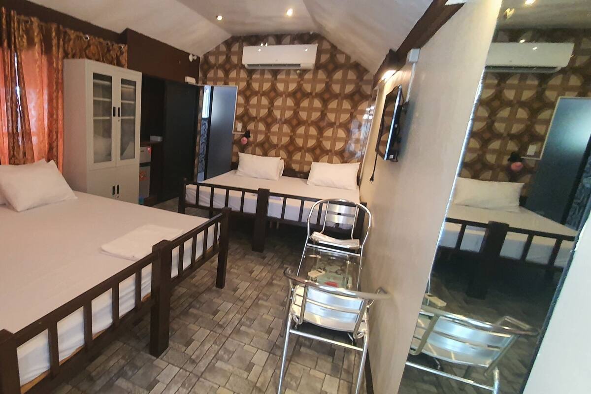 Habitación de hotel con dos camas, un armario y un espejo.