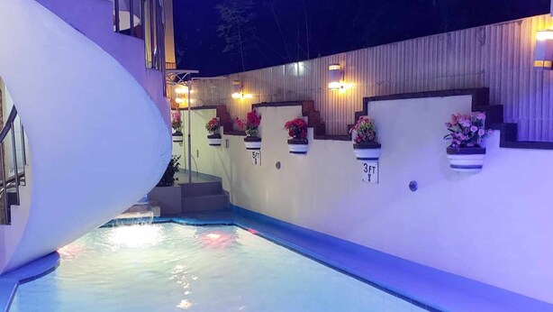 A swimming pool with a curved wall and a staircase leading to an upper level. There are flower planters on the wall and a number sign indicating room 3FT. - Cool Martin Resort Hotel (Bacoor City)