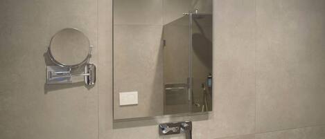 Un baño con lavamanos blanco, un espejo y un toallero.