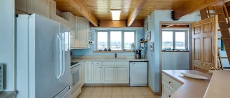 Kitchen with a window offering a view of the outside, featuring a refrigerator, stove, sink, and dishwasher.
