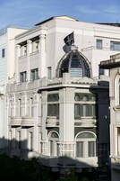 Egy klasszikus stílusú épület, melynek jellemzői a oszlopok, az íves ablakok és a feltűnő kupola.