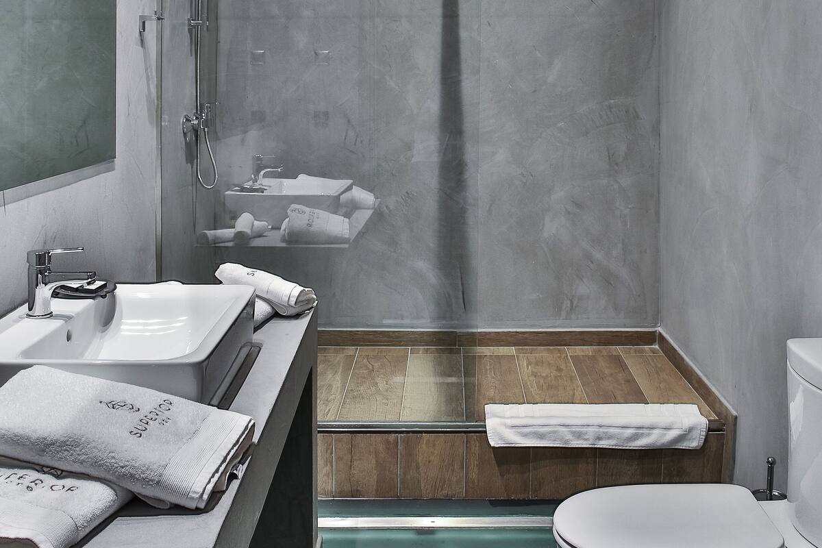 Une salle de bain moderne avec une douche à parois de verre, un lavabo avec un miroir et des toilettes.