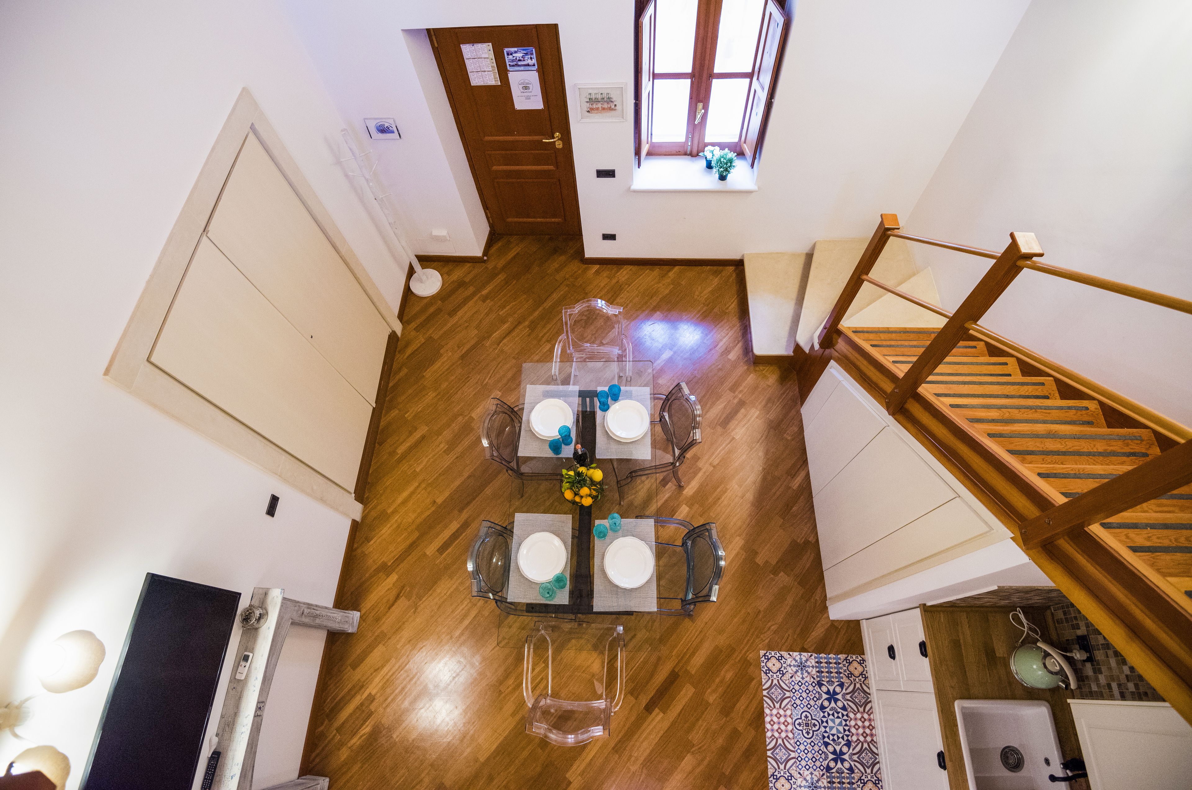Un comedor con suelo de madera, una mesa y sillas, y una escalera.