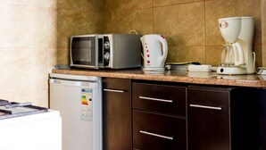 Et lille køkken med mikroovn, kaffemaskine og minikøleskab.
