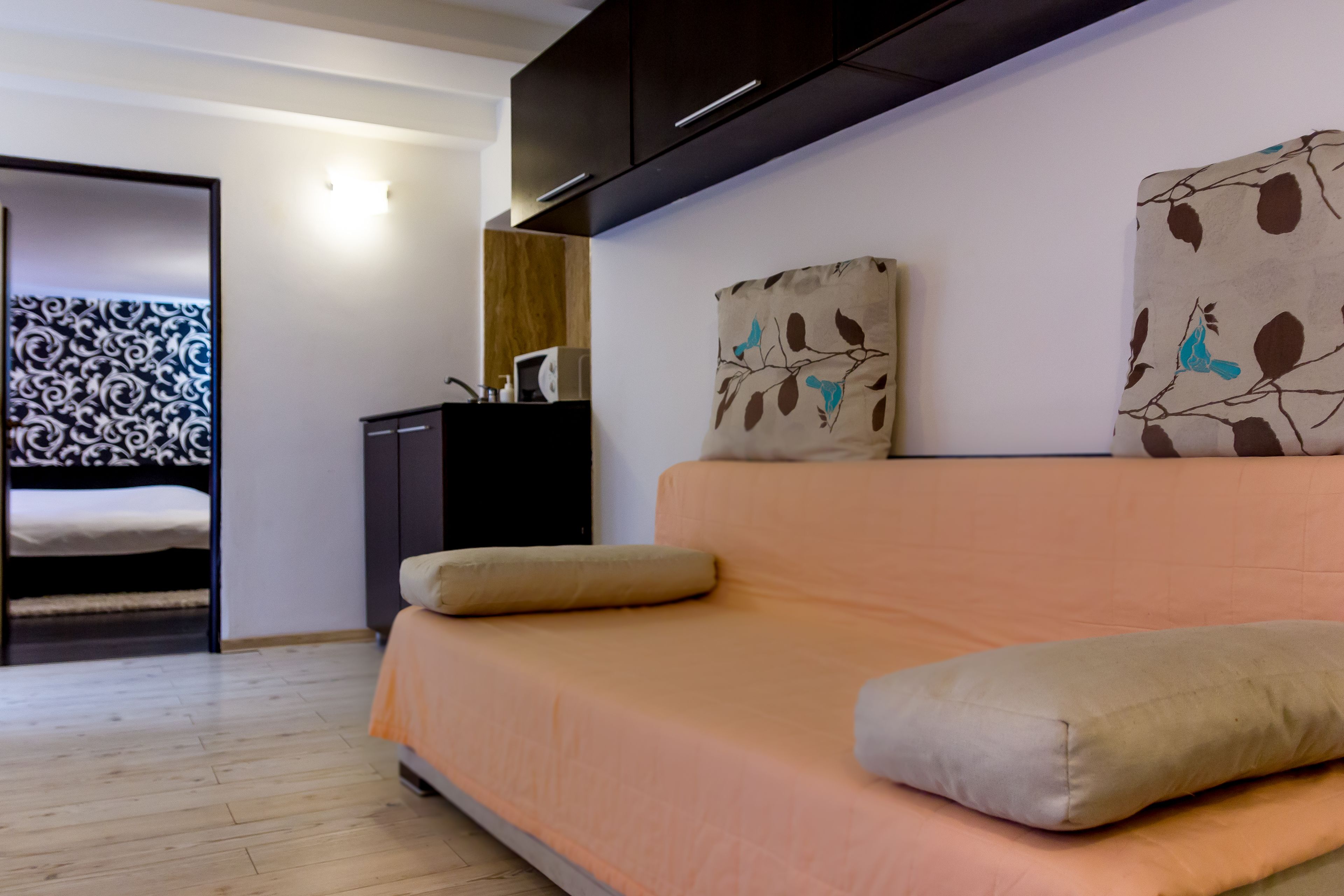 Ein modernes Wohnzimmer mit einer Couch, einem Bett und einer Wand mit abstrakter Kunst.