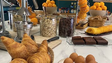 Un bufé de desayuno con pasteles, frutas y diversas opciones de comida.