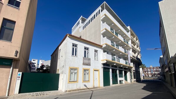 A multi-story building with a white facade, balconies, and a green gate. - Hotel Santiago Vagos (Vagos)
