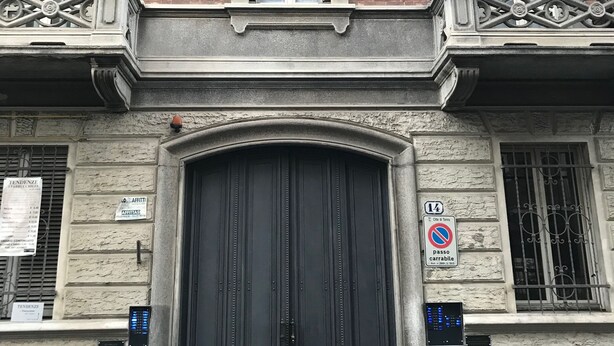 Un bâtiment doté d’une grande porte noire, d’un panneau indiquant qu’il est interdit de se garer et d’un écran numérique.