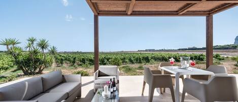 Relax in a shaded seating area under a pergola, surrounded by the scenic views of the vineyard.