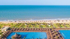 An aerial view of a resort with two swimming pools, beach umbrellas, and a beach area. - Vila Galé Resort Touros - All Inclusive (Touros)