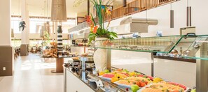 A buffet area with various food items and a large vase of flowers. - Vila Galé Resort Touros - All Inclusive (Touros)