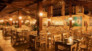 A spacious restaurant with multiple tables and chairs, wooden beams, and hanging lights. - Vila Galé Resort Touros - All Inclusive (Touros)