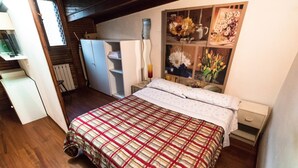 A bedroom with a bed, a wardrobe, a nightstand, and a mirror. - Mono Verde (Turin)