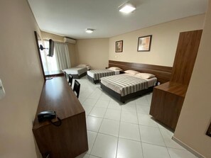 A hotel room with two beds, a desk, and a chair. - Flamboyant Suite Hotel (Porto Velho)