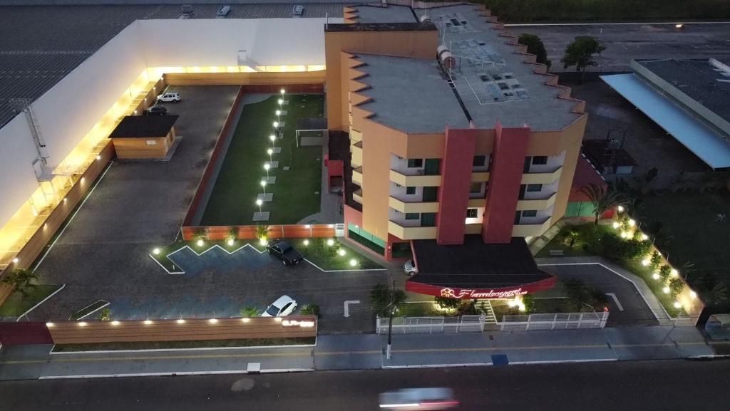 Un hotel de varios pisos con estacionamiento, piscina y zonas ajardinadas.