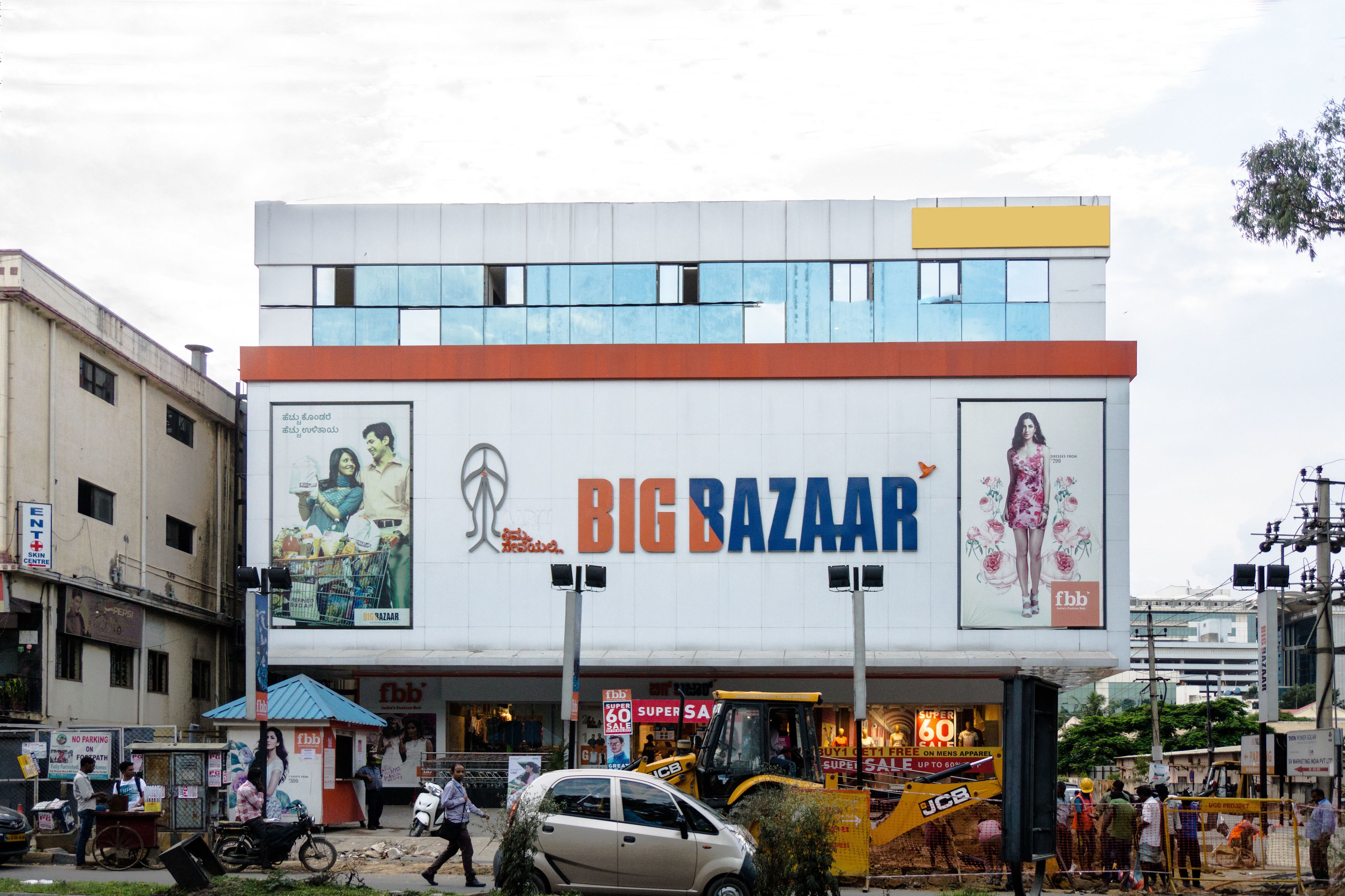 A building with a large sign reading "BIG BAZAAR" and multiple advertisements.