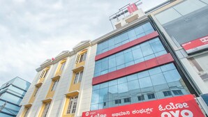 A building with a large glass facade and a prominent red sign for Abhimaani Comforts. - OYO 8501 Abhimaani Comforts (Bengaluru)