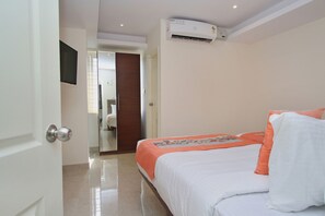 A hotel room with a bed, an air conditioning unit, a door, and a mirror. - OYO Flagship 674 HSR Layout (Bengaluru)