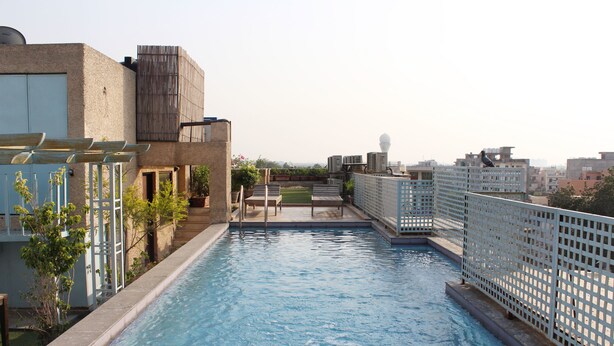 A rooftop swimming pool with a view of the cityscape.