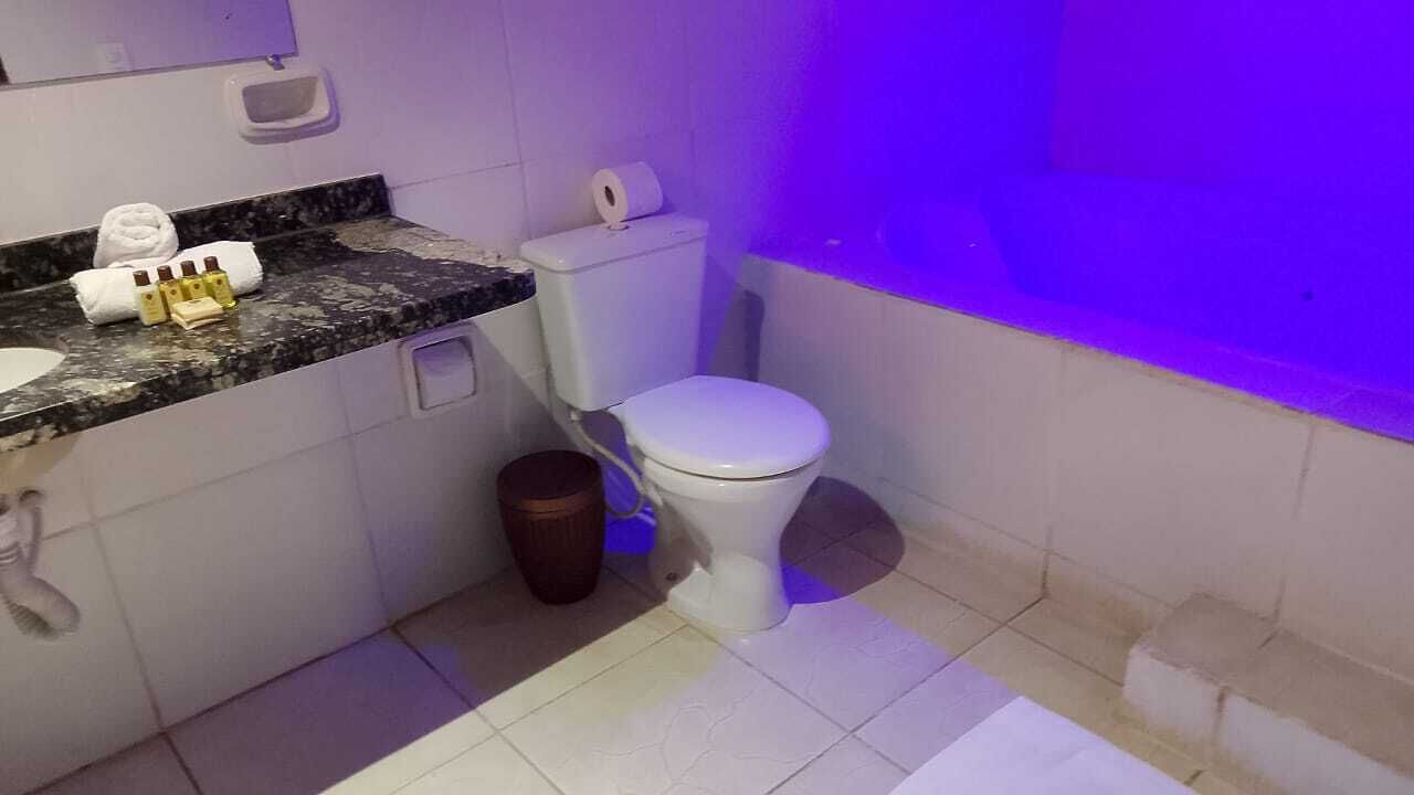A small bathroom with a toilet, sink, and a trash bin.