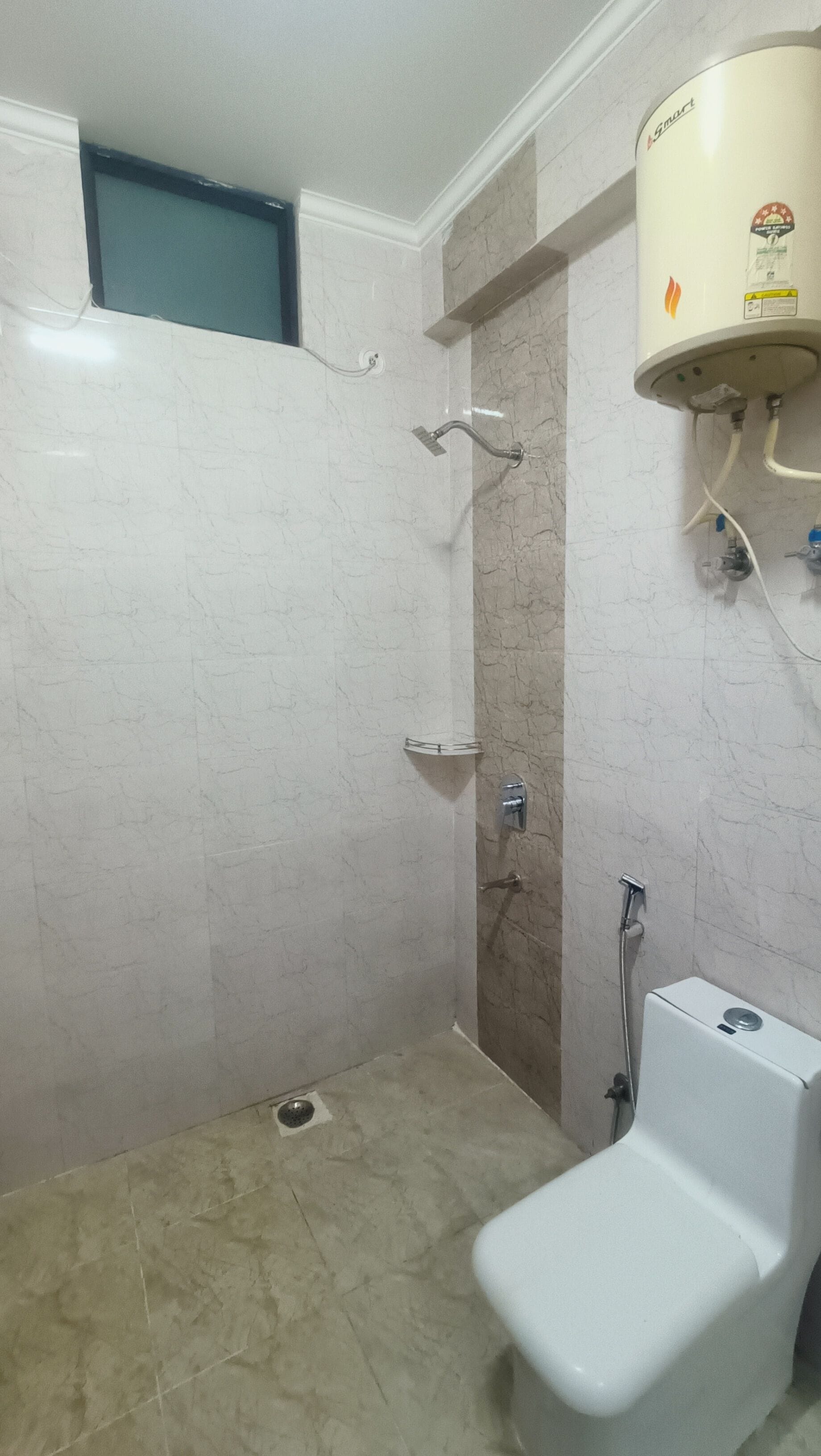Un bagno con doccia, un water e uno scaldabagno.