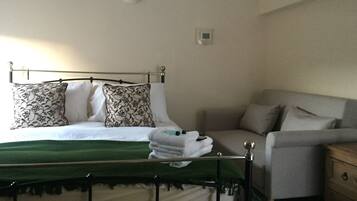 A bedroom with a bed, a bedside table, a chair, and a nightstand.