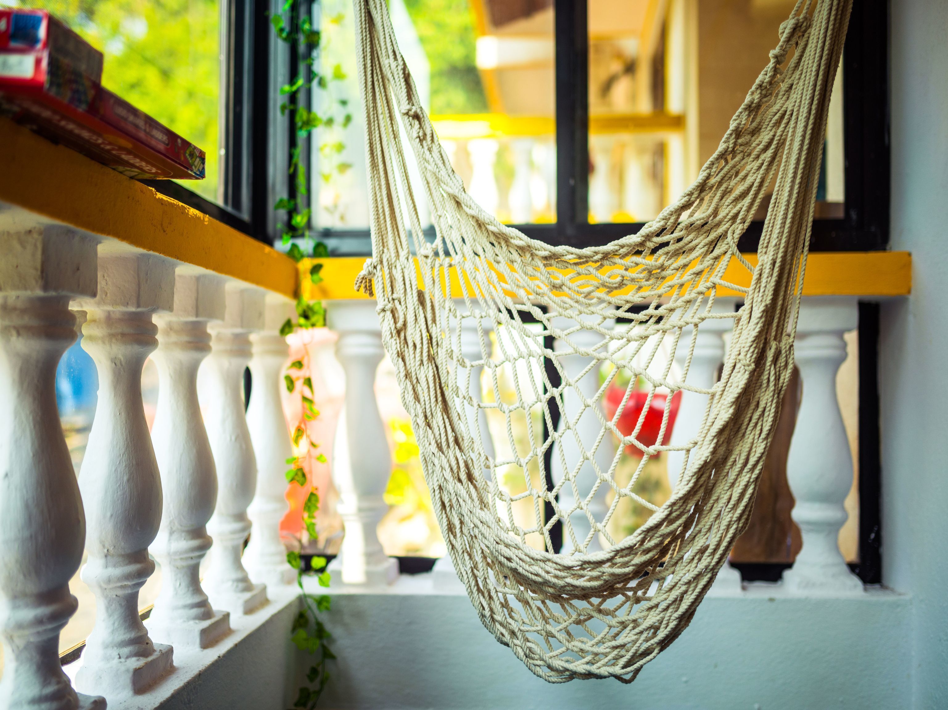 A hammock hanging from a balcony railing.