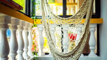 A hammock hanging from a balcony railing.