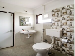 A bathroom with a toilet, sink, and mirror. - OYO Flagship 463 Banjara Hills (Hyderabad)