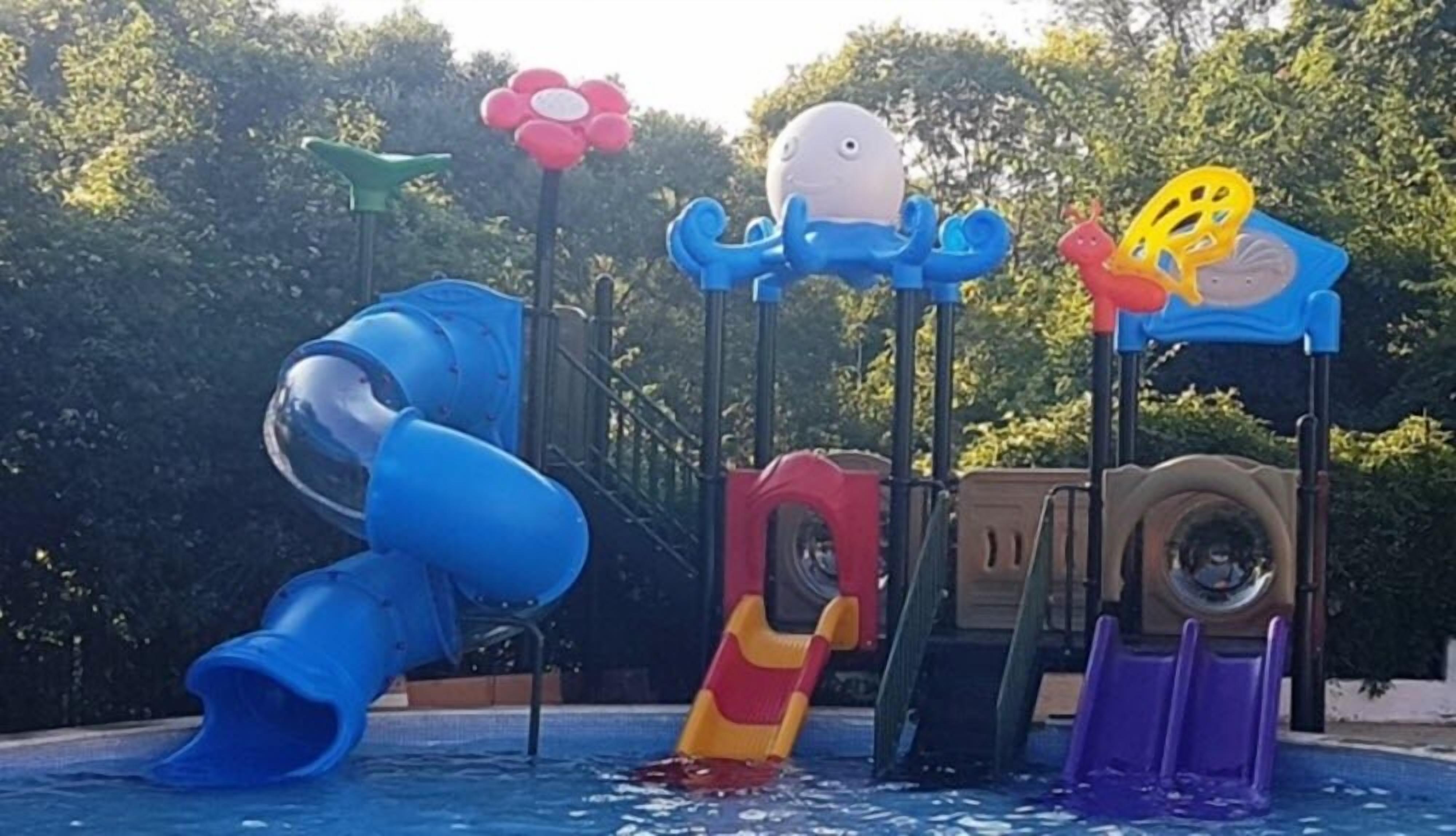 A water play area with slides and water jets shaped like sea creatures.