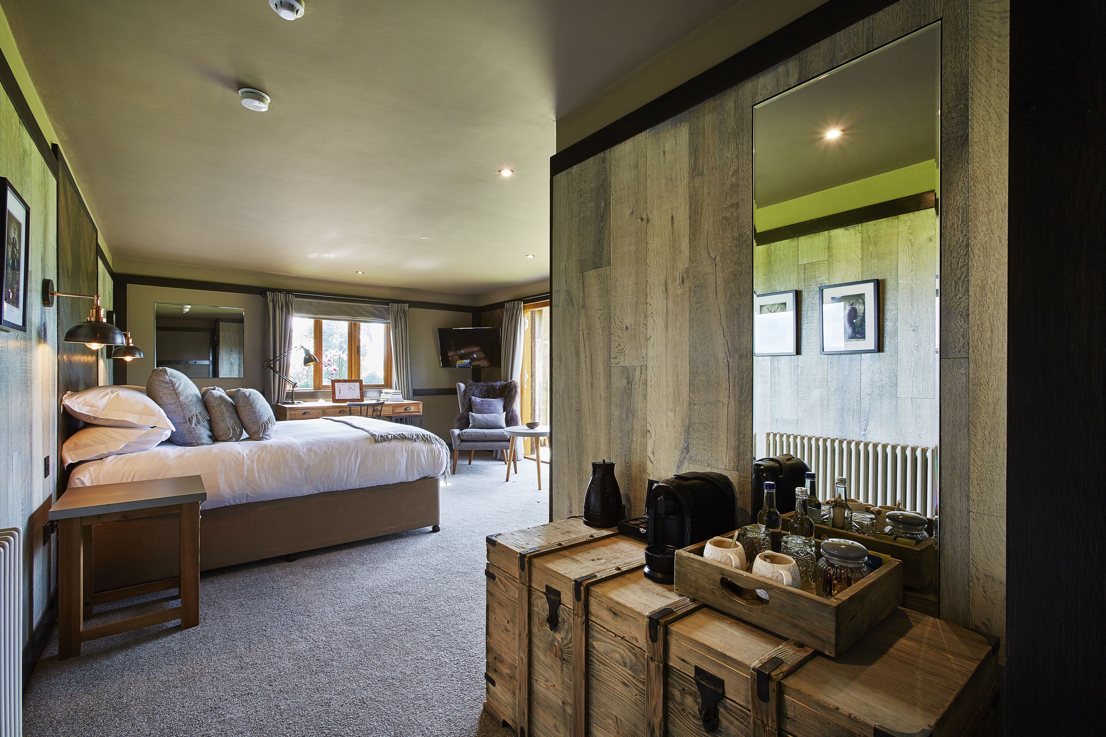 Ein Schlafzimmer mit einem großen Bett, einem hölzernen Schminktisch und einem Spiegel.