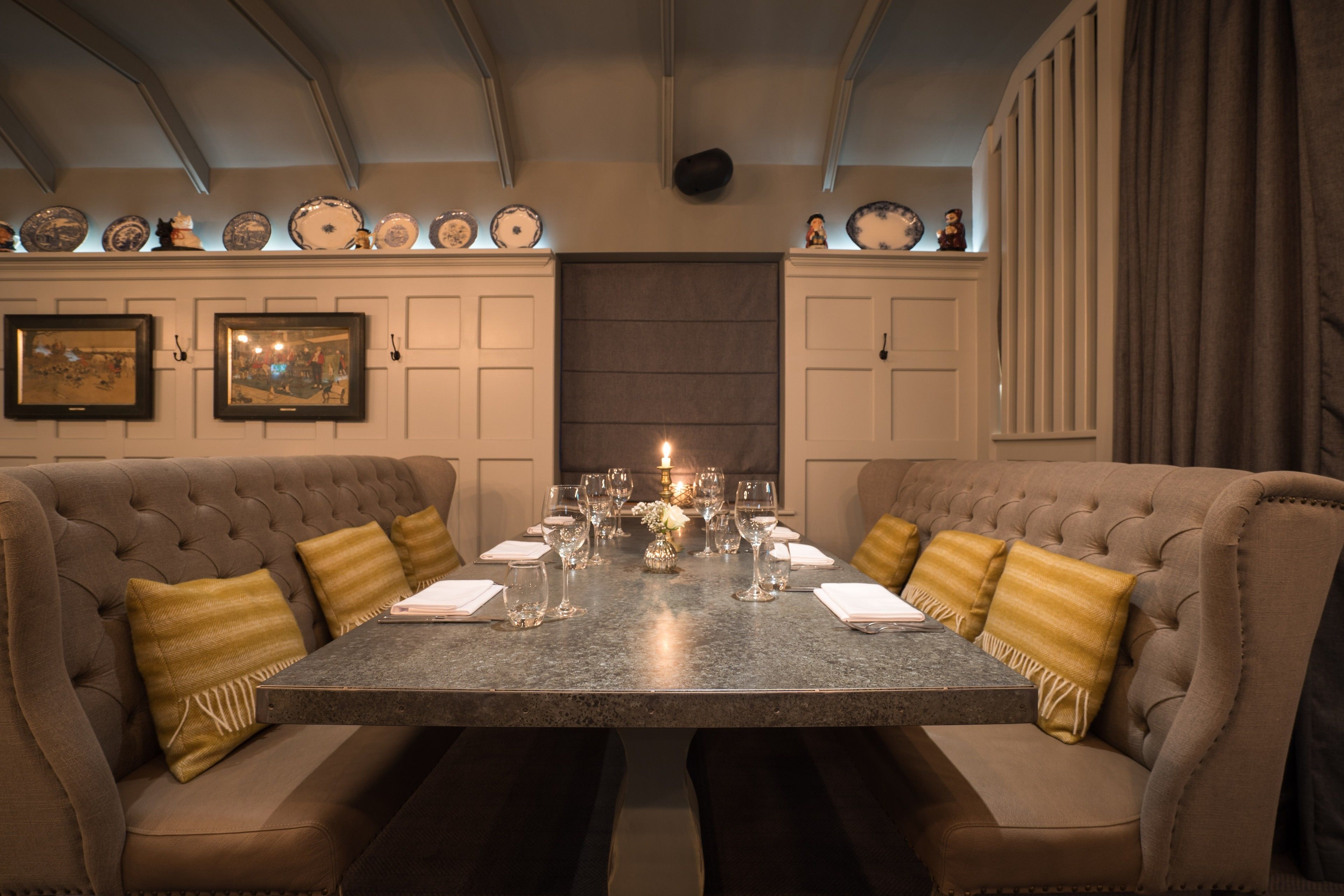 A formal dining room with a marble table, cushioned chairs, and a decorative backdrop.