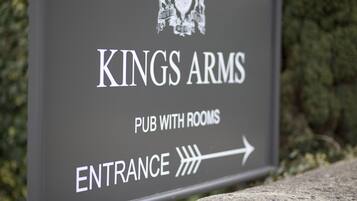 Señalización para el pub con habitaciones 'Kings Arms Pub' con una flecha indicando la entrada.