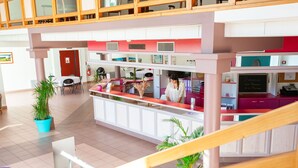 A hotel lobby with a reception desk, seating area, and a staircase. - Olydea Cassen (Cassen)