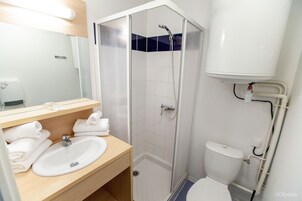A modern bathroom with a shower, toilet, and sink.