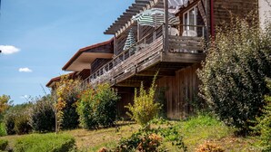 A wooden chalet with a balcony, surrounded by lush greenery. - Olydea Cassen (Cassen)