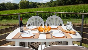 A table set for two with a bottle, wine glasses, plates, cutlery, a baguette, and a pitcher of water. - Olydea Cassen (Cassen)