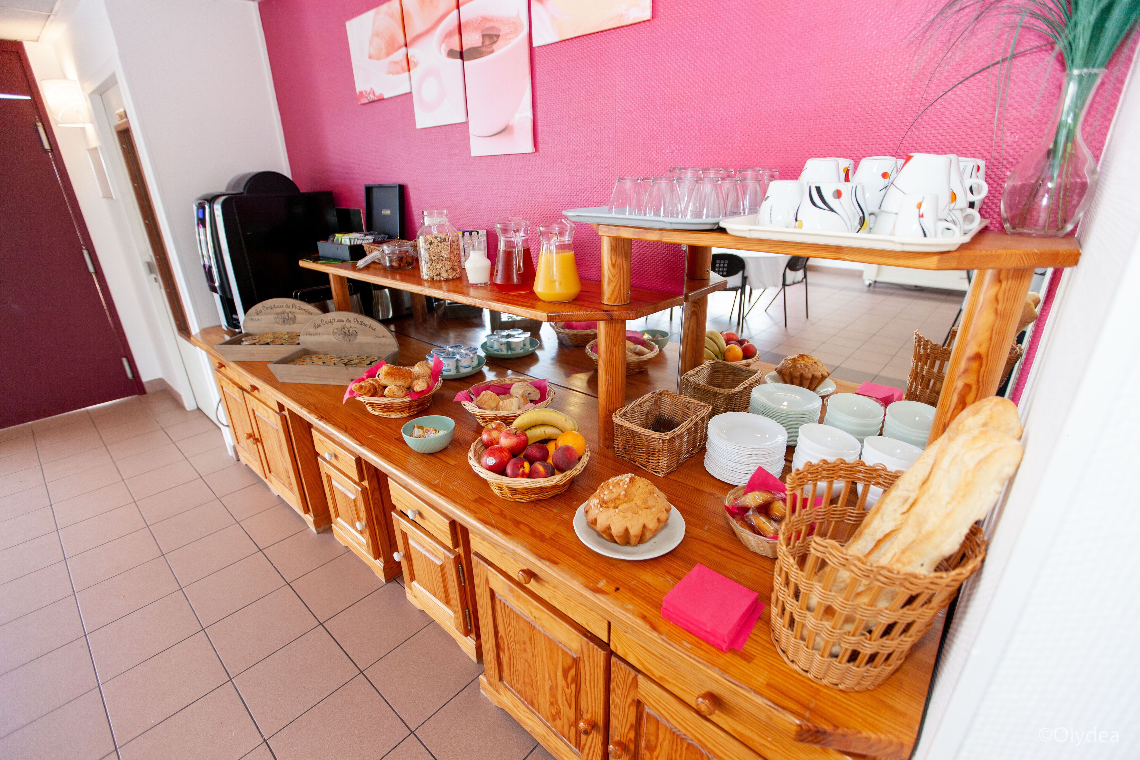 Un bufé de desayuno con diferentes alimentos y bebidas, como frutas, pasteles y pan.