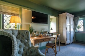 A room with a wooden desk, a chair, a lamp, a television, and a cabinet. - The Mayflower (Lymington)